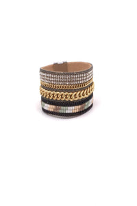 Bracelet manchette large orné de différente chaine et de strass avec fermeture aimanté.
